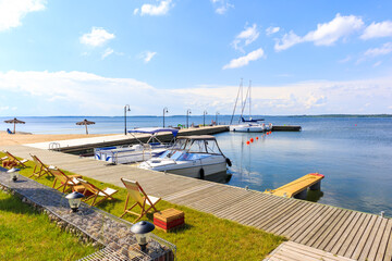 Yacht boats at pier in sailing port Nowe Guty on Lake Sniardwy on summer sunny day,  Masurian Lakes, Poland