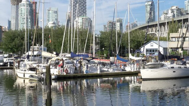 boats parked at granville island with vancouver house backdrop