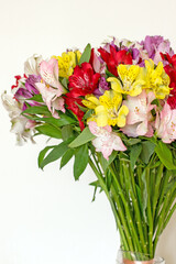 Alstroemeria bouquet of flowers in a vase by the window. Beautiful bouquet of colorful flowers in the apartment by the window.