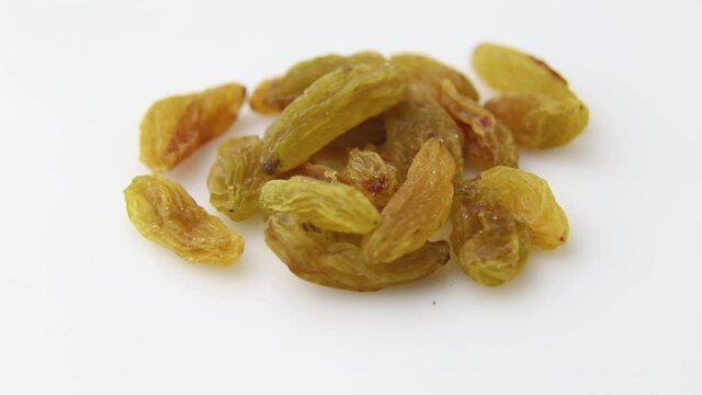 Rotating of raisins on white background. Side view, close up.