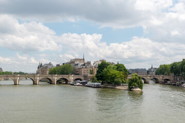View over the river seine to the bridge Pont Neuf and the towers from Notre Dame in the background.