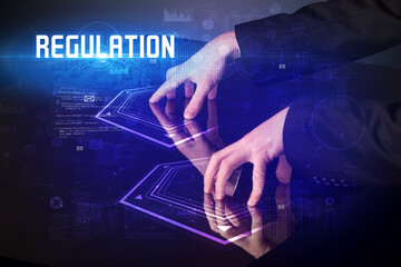 Hand touching digital table with REGULATION inscription, new age security concept