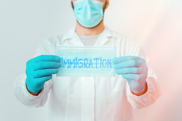 Writing note showing Immigration. Business concept for the action of coming to live permanently in...