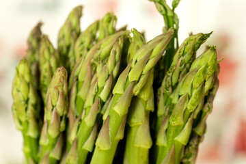 Close Up of Asparagus Tips Against a White and Peach Background