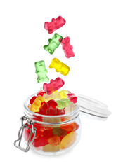 Delicious jelly bears falling into jar on white background