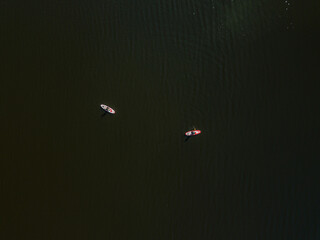 Obraz premium Two kayak boats are sailing along the Dnieper River. Sunny summer day, aerial drone view.