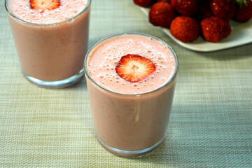 Fruit and berry smoothies in glasses close-up. Drink with slices of strawberry.