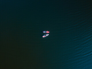 Two kayak boats are sailing along the Dnieper River. Sunny summer day, aerial drone view.