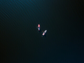 Obraz na płótnie Canvas Two kayak boats are sailing along the Dnieper River. Sunny summer day, aerial drone view.