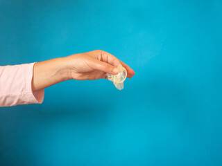 Hand with preservative on blue background with copy space