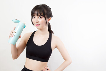 スポーツウェアで水筒を持つ若い女性