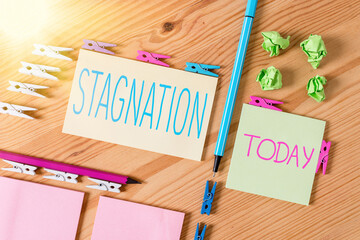 Handwriting text writing Stagnation. Conceptual photo condition marked by lack of flow, movement, or development Colored clothespin papers empty reminder wooden floor background office