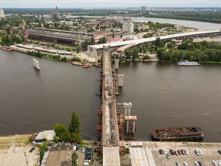Obraz premium Aerial drone view. Unfinished construction of a bridge over the Dnieper river in Kiev.