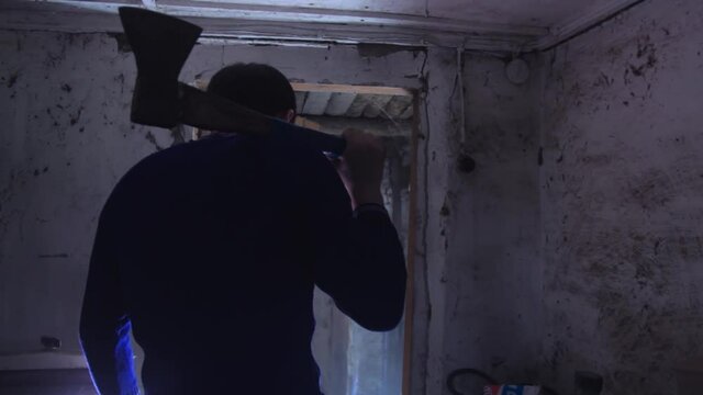copy space. A man with an axe was standing and breathing deeply. Rear view