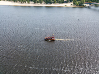 Aerial drone view. A pirate motor boat sails along the Dnieper River in Kiev.