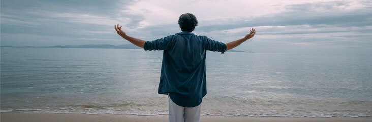 A lonely man walks along the beach on a cloudy day