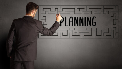 businessman drawing maze with PLANNING inscription, business education concept