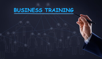 Man pointing at virtual screen with inscription BUSINESS TRAINING on dark background, closeup