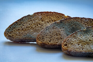 slices of rye bread covered in mold. Spoiled bread