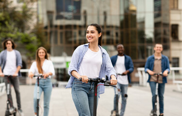 Friends having ride on motorized kick scooters