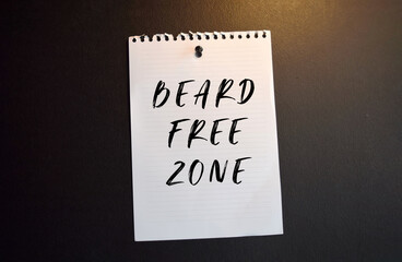 Paper note with BEARD FREE ZONE written on black slate board