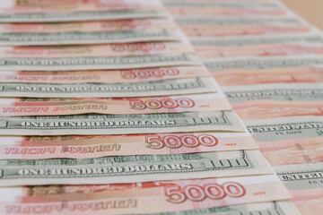 A large number of American hundred dollar bills and Russian five thousand dollar bills