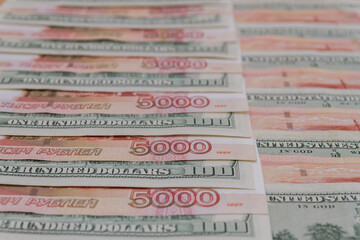 A large number of American hundred dollar bills and Russian five thousand dollar bills