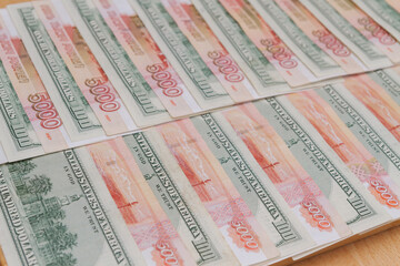 Fototapeta na wymiar A large number of American hundred dollar bills and Russian five thousand dollar bills