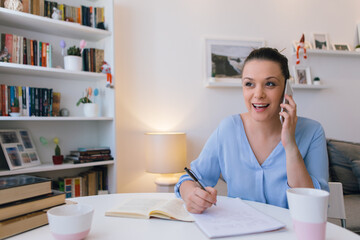 Young woman working at home and using mobile phone