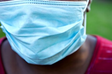 Black female face with medical mask covering her mouth and nose