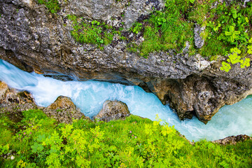 Mountain landscape with a blue stream and green vegatation
