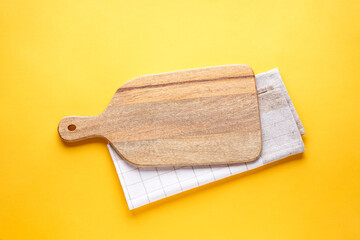 Kitchen utensils with a towel on a yellow background with space for text, top view.