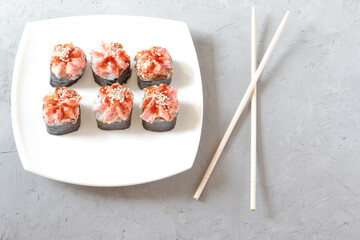 Japanese sushi with chopsticks on a grey concrete background. Top view