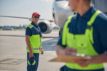 Airport worker in sunglasses standing at the airdrome