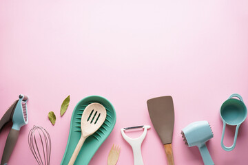 Various kitchen utensils with space for text on a pink background. Top view.