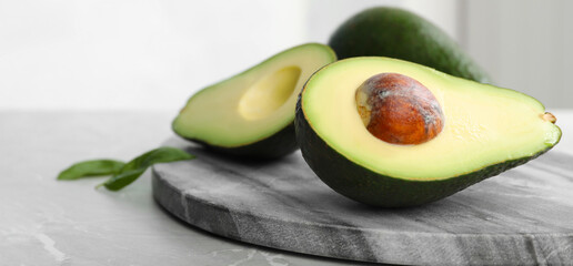 Halves of ripe avocado on table, space for text. Banner design