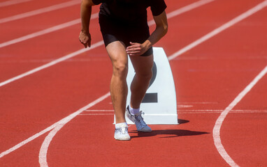 Runner in start position prepares for the start.  Individual sport conept