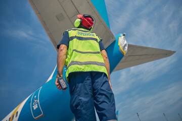 Mechanic examining the tail of the plane