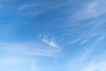 Blue sky with whispy cirrus clouds streaking past