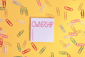 Writing note showing Ownership. Business concept for the state, relation, or fact of being an owner or with a group Flat lay above empty paper with copy space and colored paper clips