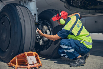 Focused professional male technician checking the undercarriage