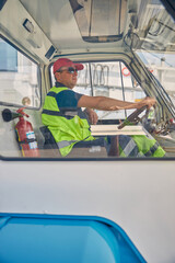 Focused airport worker sitting inside a vehicle