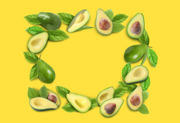 Frame of ripe avocados on yellow background. Space for text