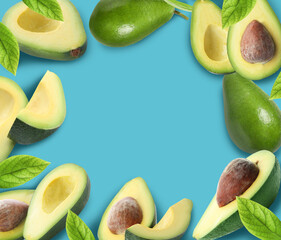 Frame of ripe avocados on blue background. Space for text