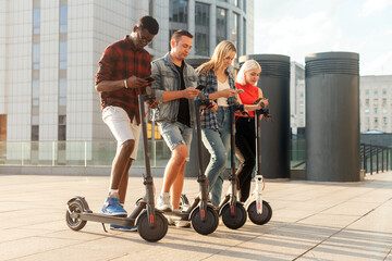 interracial group of friends rent electric scooters with telephones, multiracial youth connect with smartphones to eco transport, eco transport rental concept
