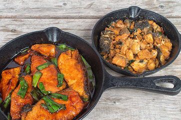 Vietnamese simmered salmon in cast iron pan on a wooden table