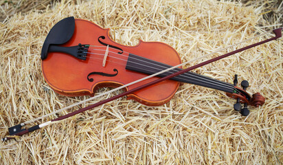 One violin and bow placed on a pile of straw in the field. Music Violin training