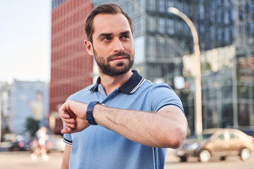 Young businessman using smartwatch in urban street