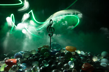 Musical symbol treble clef stainless steel miniature with colorful toned light on foggy background....