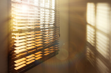 Sun shining through window blinds in room